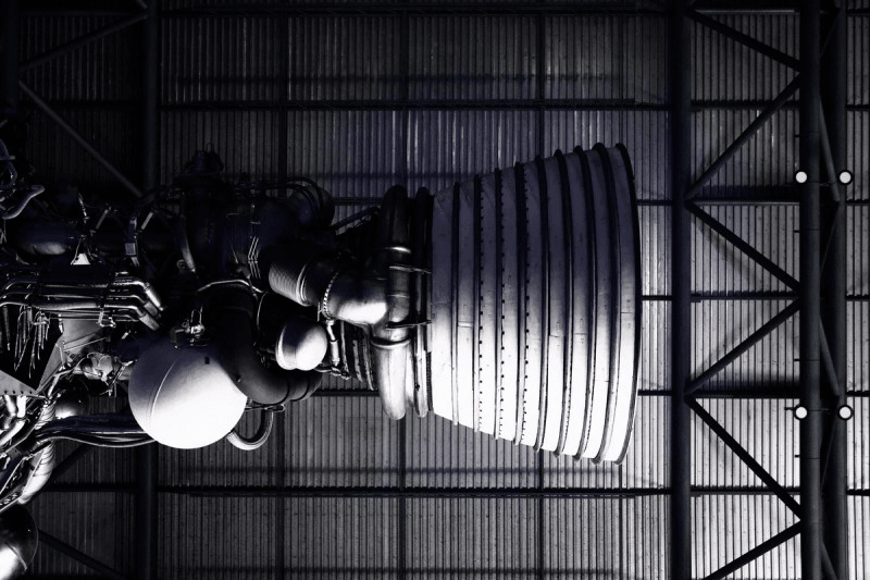 Rocket booster viewed from below with metal hanger ceiling above