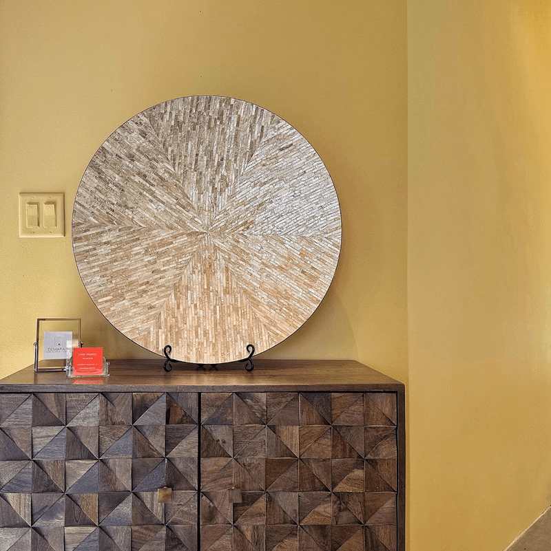 Hall table against a yellow wall with large decorative plate and interior designer business cards displayed